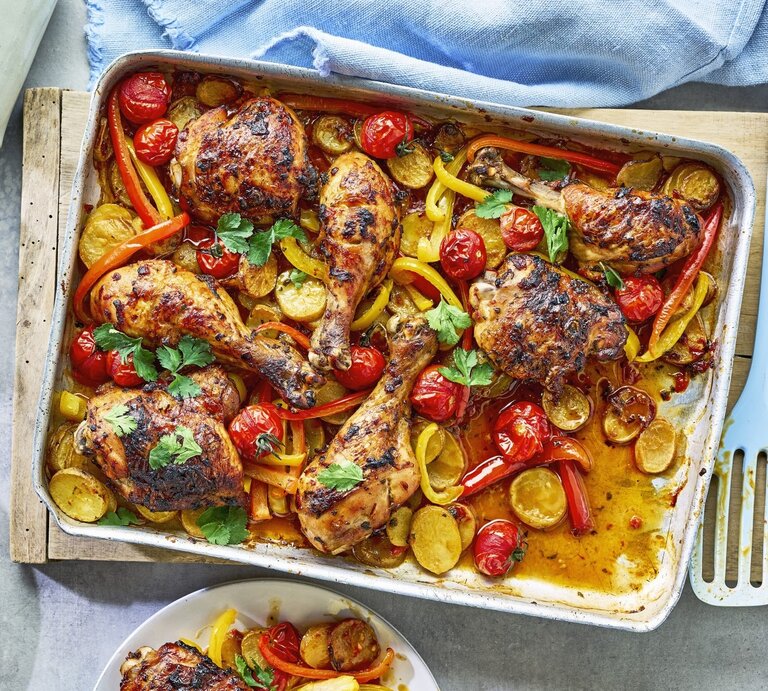 In einer Ofenform ist eine Portion Piri-Piri-Hähnchen vom Blech angerichtet. Dazu gibt es Paprika. | © StockFood / Immediate Media / Good Food
