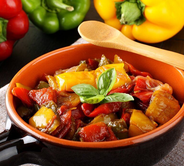 Eine Schüssel mit Peperonata auf einem Küchentuch. | © Shutterstock/lorenzo_graph