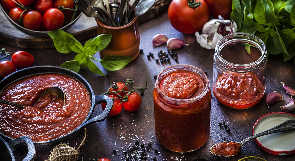 Rustikale Umgebung mit verschiedenen Zutaten zum kochen einer Tomatensoße.