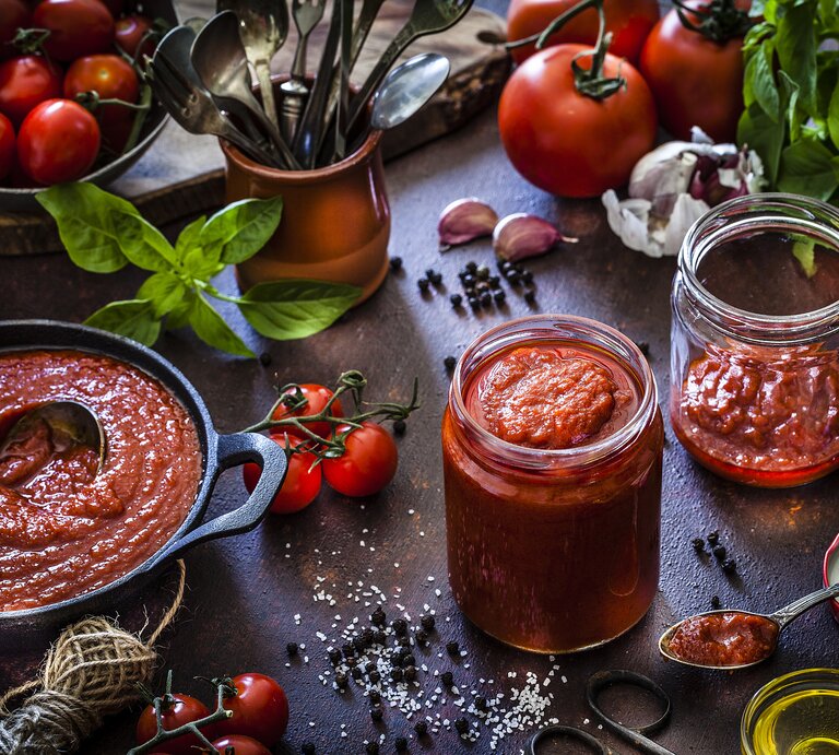 Rustikale Umgebung mit verschiedenen Zutaten zum kochen einer Tomatensoße. | © Getty Images/ fcafotodigital