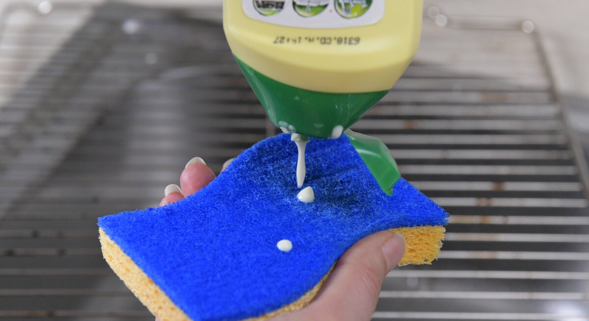 Scheuermilch wird auf einem Putzschwamm verteilt.