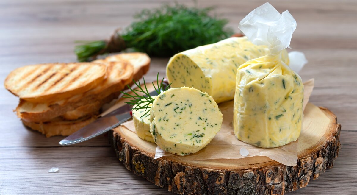 Eine Rolle mit Dill-Zitronenbutter auf einer Baumscheibe.