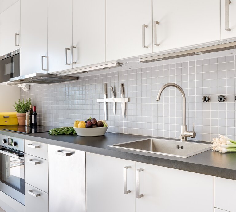 Moderne Küche mit einem eleganten und sauberen Design. Die Küchenzeile ist in Weiß gehalten, mit flächenbündigen Schränken und Edelstahlgriffen.  | © Niklas Skur / EyeEm / GettyImages