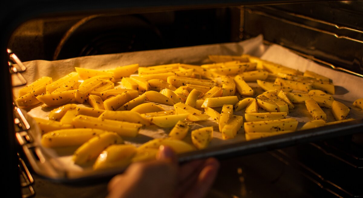 Ein Backblech mit Pommes im Ofen.