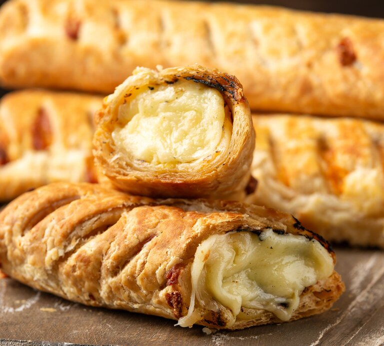 Gefüllte Blätterteig-Brötchen mit Käse & Zwiebeln auf Holzbrett. | © Getty Images/DronG