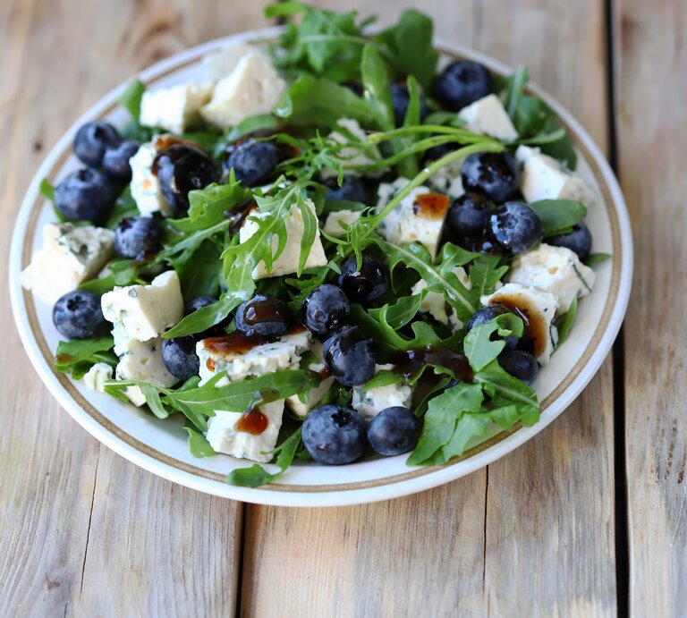 runder Teller / Rucola-Salat mit Feta und Blaubeeren / Untergrund Holz / Draufsicht / nahaufnahme | © Shutterstock / Sunvic