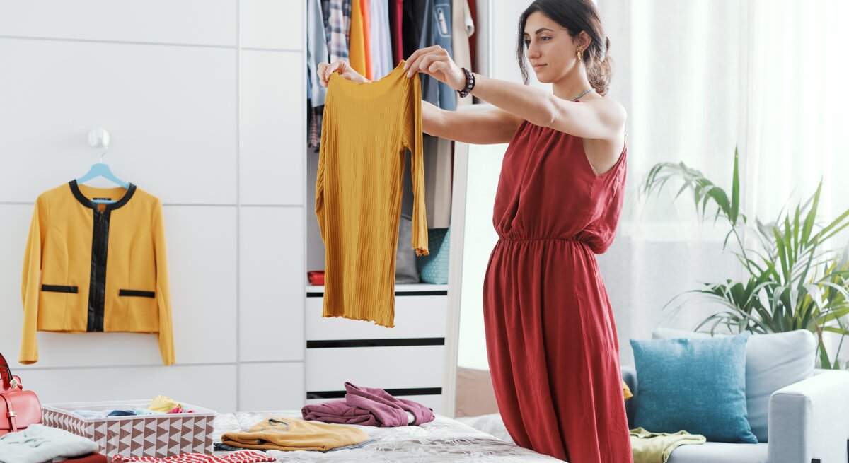 Eine Frau mistet gerade ihren Kleiderschrank aus.