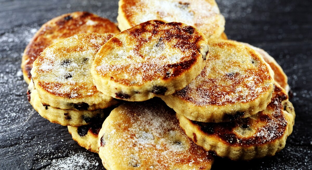 Mehrere Welsh Cakes auf einem dunklen Schieferuntergrund.