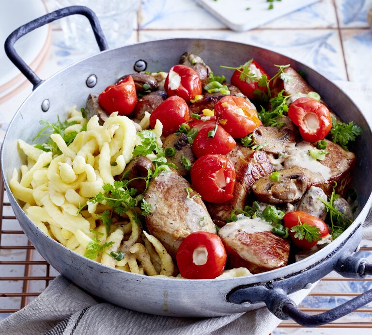 Spätzle-Jägerpfanne mit Pilzen, gerösteter Papika und frischer Petersilie, serviert in einer rustikalen tiefen Pfanne auf einem Keramiktisch.  | © EAT CLUB / Isabell Triemer