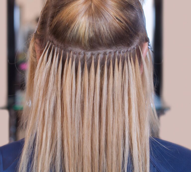 Hinterkopf einer Person mit einer speziellen Frisur. Zu sehen sind Extensions, die mittels der Tape-in-Methode befestigt wurden. | © iStock.com/dimid_86