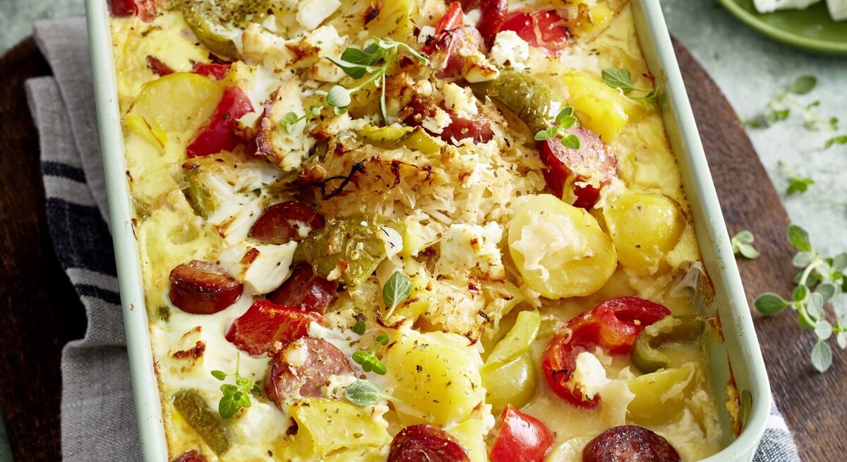 In einer Auflaufform ist eine Portion Ungarischer Sauerkraut-Auflauf serviert. Das Gericht ist mit Oregano garniert.