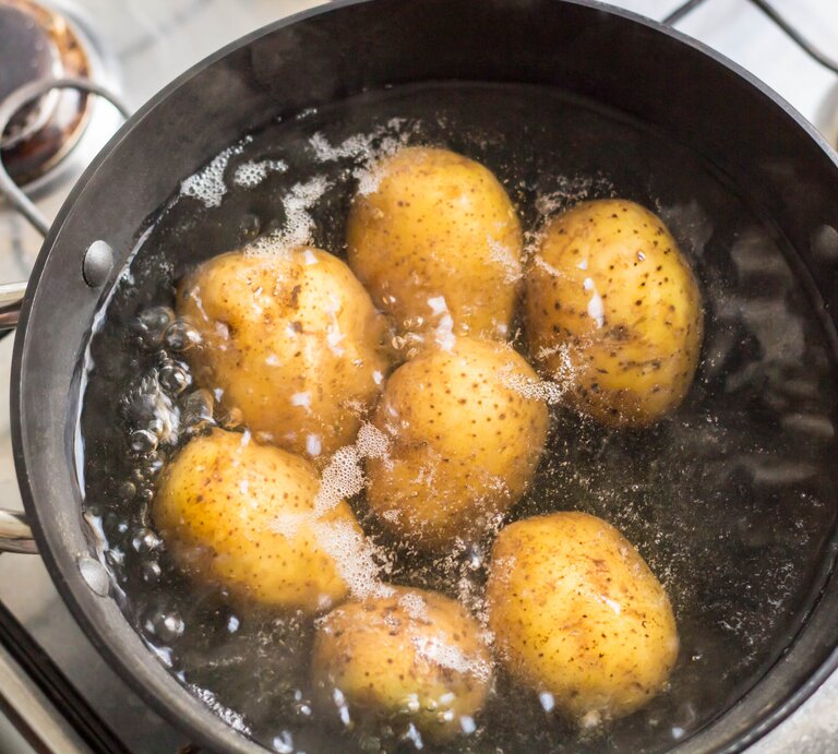 Ein Kochtopf mit kochendem Wasser und Kartoffeln. | © Shutterstock/dashtik