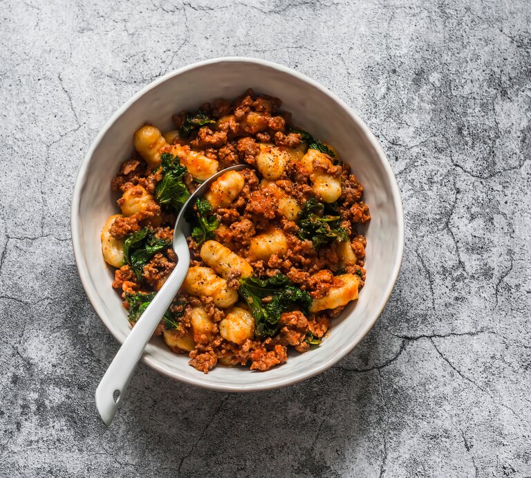 Aus der Vogelperspektive sieht man eine Gnocchi-Hack-Pfanne. | © Shutterstock / Kiian Oksana
