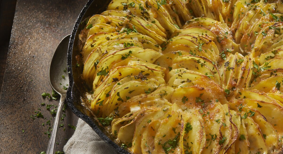 Gusseiserne Form mit überbackenen Kartoffelblättern. 