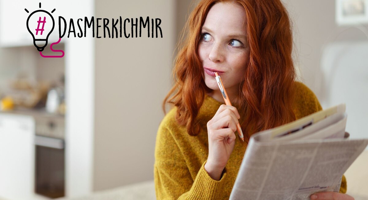 Eine Frau mit rotem Haar und einem senfgelben Pullover liest nachdenklich eine Zeitung und hält dabei einen Stift an ihre Lippen. Ihr Blick ist nachdenklich und reflektierend, als würde sie über das Gelesene nachdenken oder eine Pause machen, um ihre Gedanken zu sammeln. Neben ihrem Kopf ist der Hashtag "#DAS MERK ICH MIR" neben einer stilisierten Glühbirnen-Grafik zu sehen, was darauf hindeutet, dass sie gerade eine Idee oder einen wichtigen Punkt zum Merken gefunden hat. 