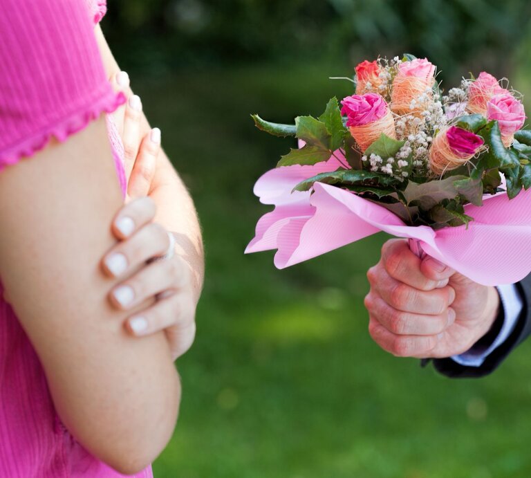 Mann überreicht Frau Blumenstrauß, von beiden Personen sind nur die Hände zu sehen | © iStock.com/KatarzynaBialasiewicz