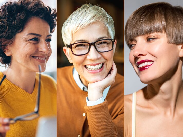 Drei Frauen mit unterschiedlichen Kurzhaarfrisuren. Die erste Frau links hat lockiges Haar. Die Frau in der Mitte trägt eine Brille und hat kurzes, silbernes Haar, das stilvoll nach vorne gestylt ist. Die dritte Frau rechts hat glattes, braunes Haar in einem modernen Bob-Schnitt mit Pony. Alle drei Frauen lächeln. | © iStock, Shutterstock [M]