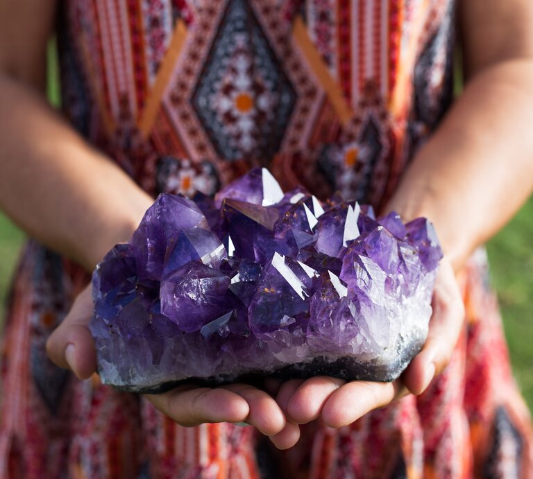 Eine Frau hält einen großen Amethyst in der Hand.  | © Shutterstock/Charlie Blacker