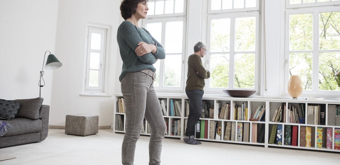 Paar schaut nachdenklich und mit Abstand aus dem Fenster | © Getty Images /	Westend61