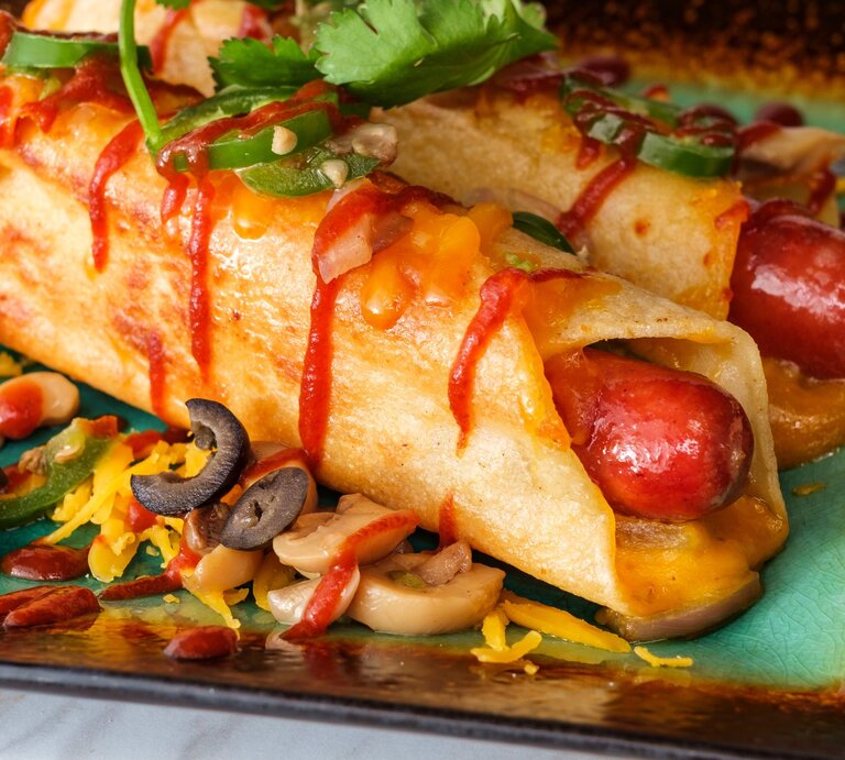 Low Carb Hot Dogs mit Toppings auf buntem Teller. Draufsicht. | © Getty Images / EzumeImages