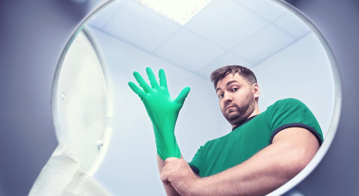 Ein Mann steht vor einer Toilette und ist bereit zum Badputz.