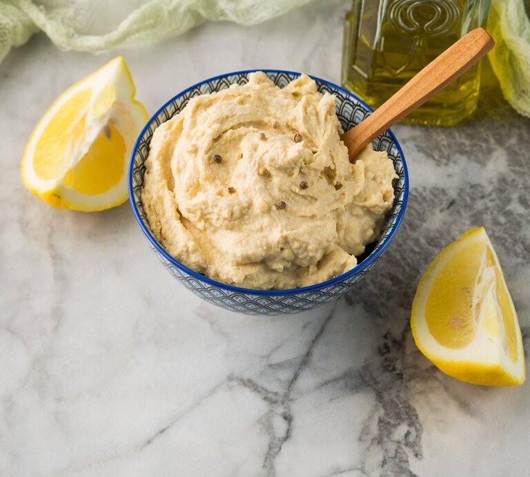 Schüssel / Zitrus-Hummus / Zitronenspalten / Marmortisch / Nahaufnahme / Draufsicht, schräg | © Shutterstock/Life morning