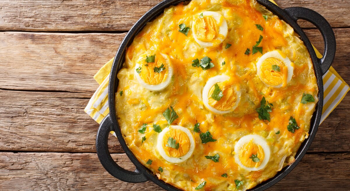 Anglesey Eggs in gusseiserner Pfanne auf hölzernem Untergrund. 
