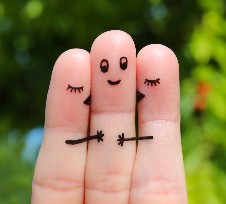 Polyamorie, anhand von drei bemalten Fingern dargestellt, die zwei Männer und eine Frau symbolisieren | © Shutterstock / Victoria 1