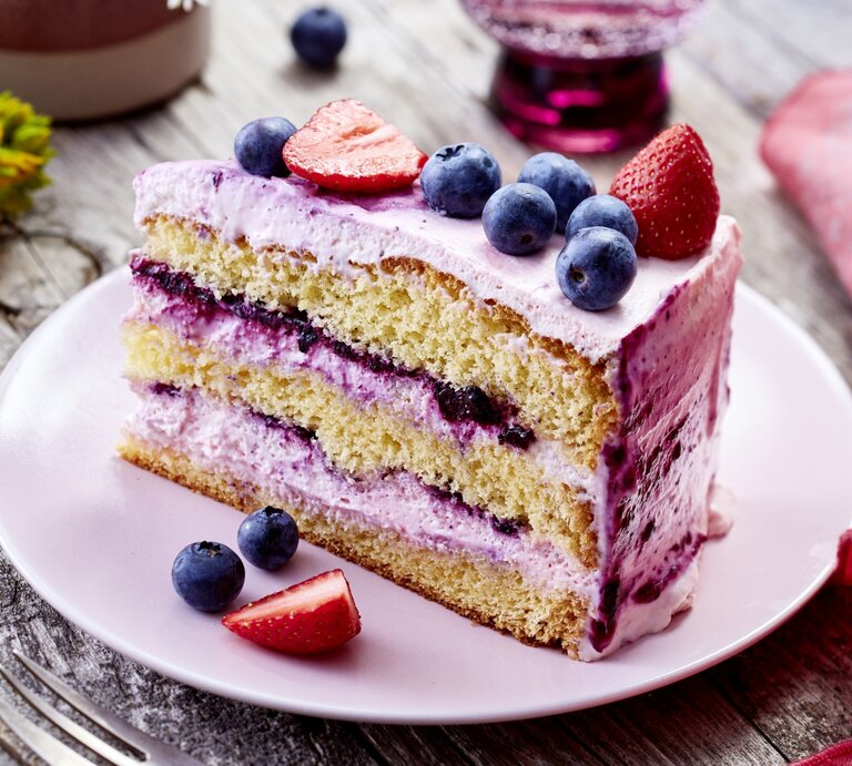 Die Frischkäse-Biskuittorte mit Blaubeeren und Erdbeeren ist nicht nur geschmacklich herausragend, sondern auch eine gute Wahl für alle, die Wert auf frische Zutaten und selbstgemachte Köstlichkeiten legen. | © EAT CLUB / Isabell Triemer
