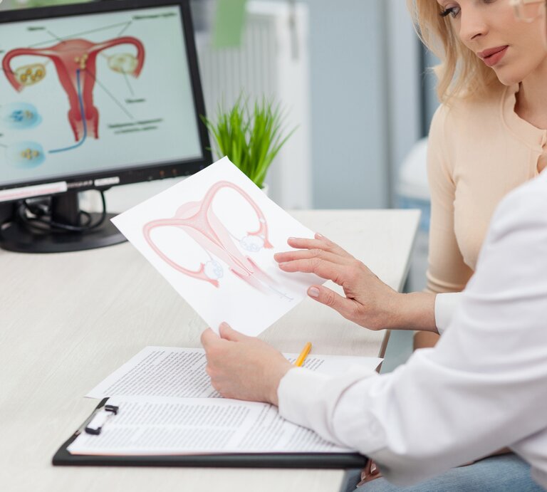 Junge Frau bekommt von ihrer Frauenärztin erklärt, dass sie eine Gebärmutterentzündung hat. Sie sitzen am Schreibtisch, vor einem PC.  | © iStock/YakobchukOlena