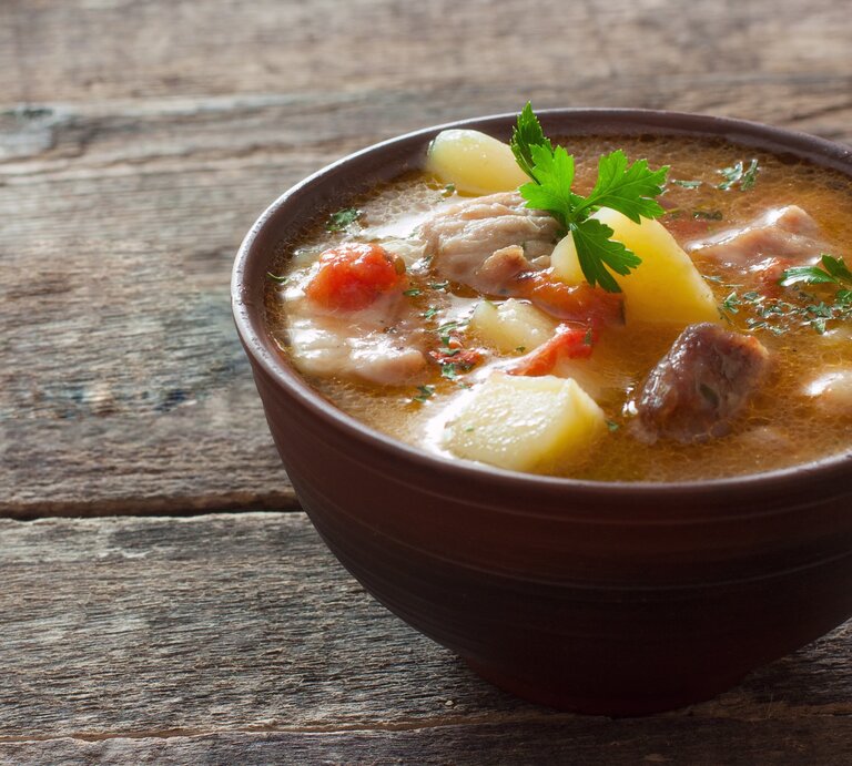 Eine braune Schale mit dem Thüringer Bierfleisch auf einem dunklem Holztisch. | © Shutterstock/ annata78
