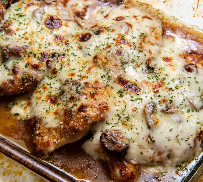 Eine Auflaufform mit Hähnchen und überbackenem Käse in der Draufsicht. | © Gettyimages/ EzumeImages