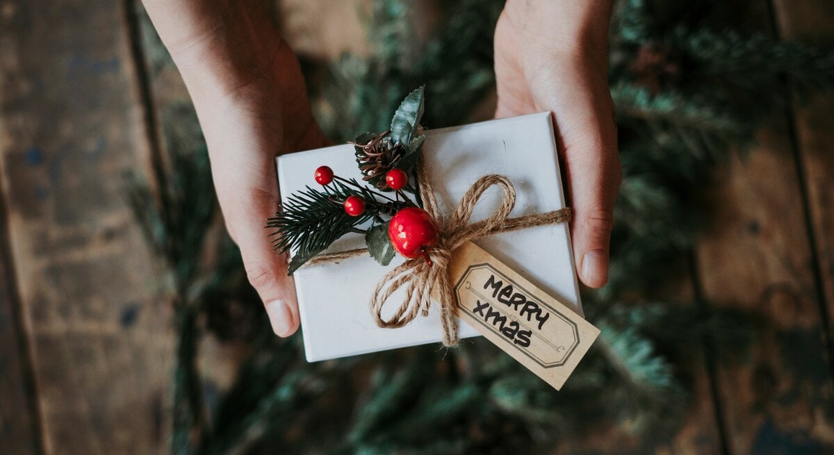 Eine Person hält ein verpacktes Geschenk in der Hand.