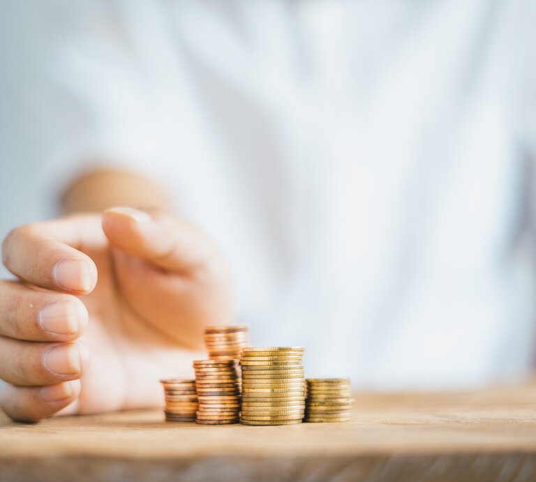 Stapel an Münzen auf einem Tisch. | © Adobe Stock/ artrachen