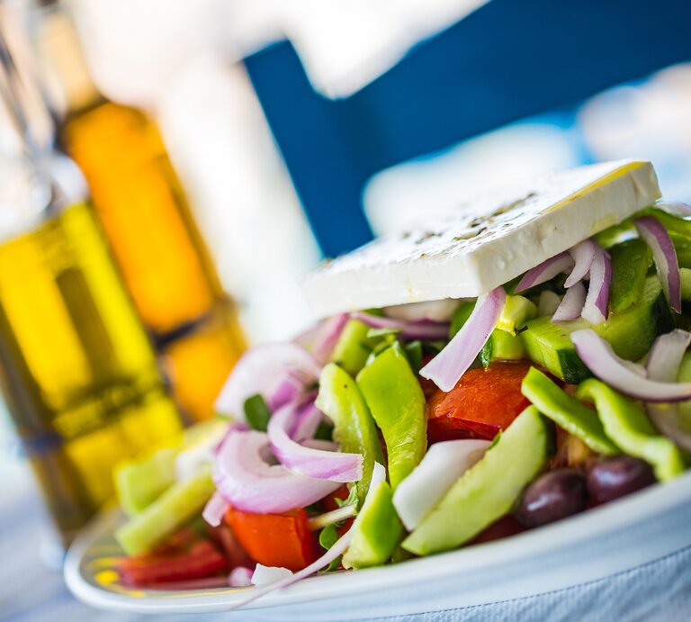Ein mit Feta garnierter griechischer Salat auf einem Teller.  | © iStock/mbbirdy 
