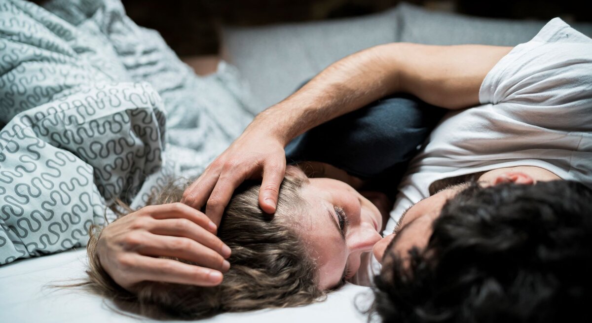 Mann und Frau im Bett, schauen sich an