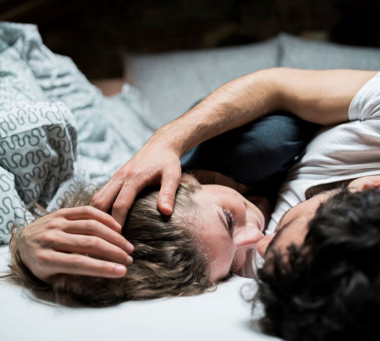 Mann und Frau im Bett, schauen sich an | © Getty Images / Arno Images