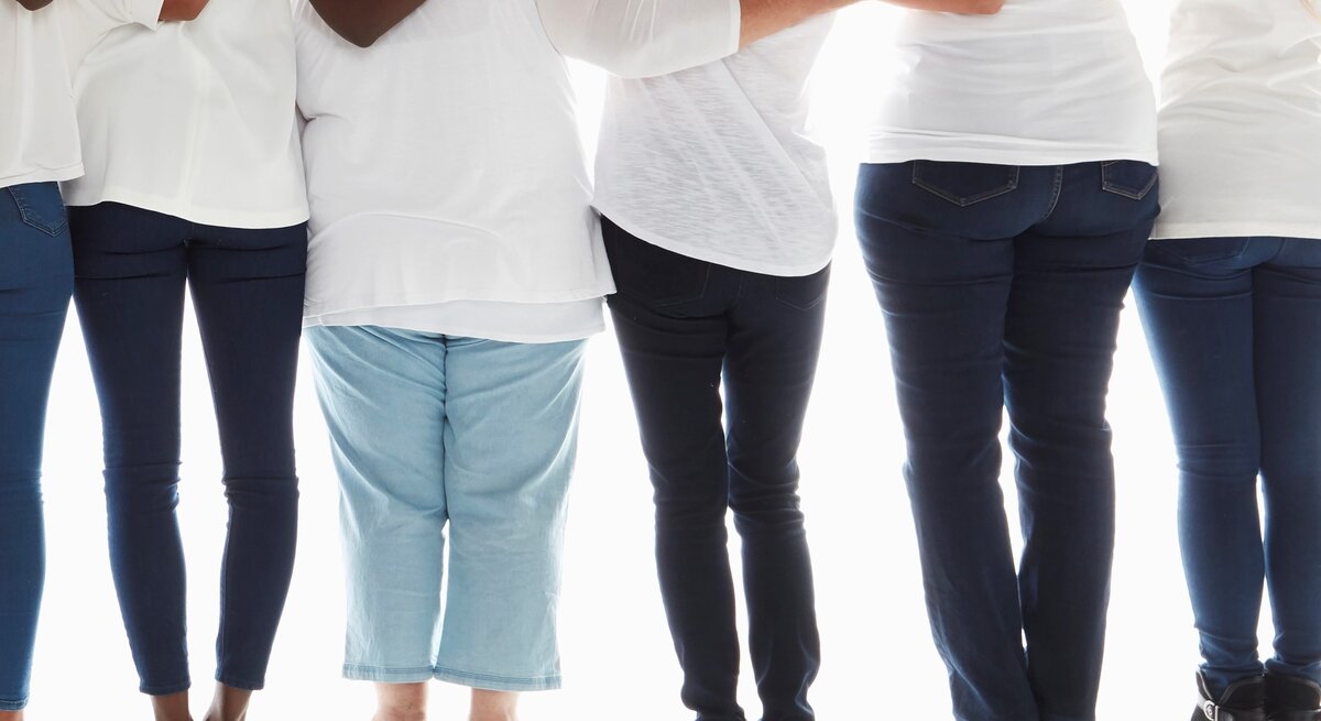 Die Beine von sechs Frauen von hinten, alle tragen Jeans