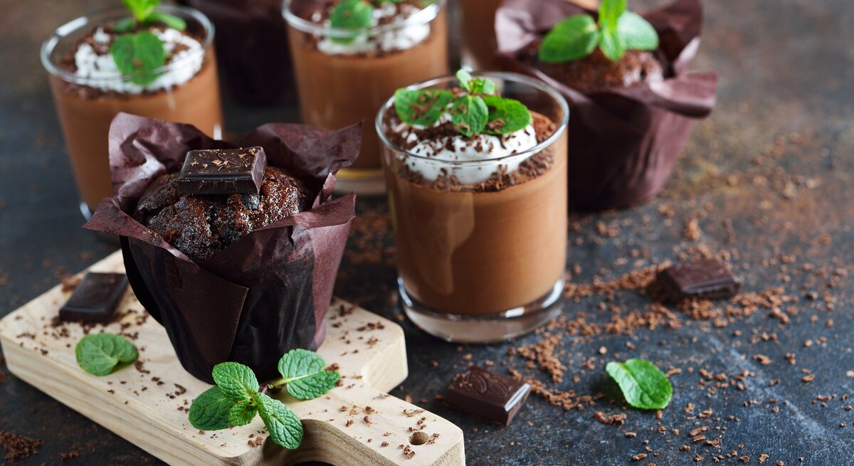 After-Eight-Mousse mit Sahne, Schokoraspeln und Minze auf dunklem Untergrund. 