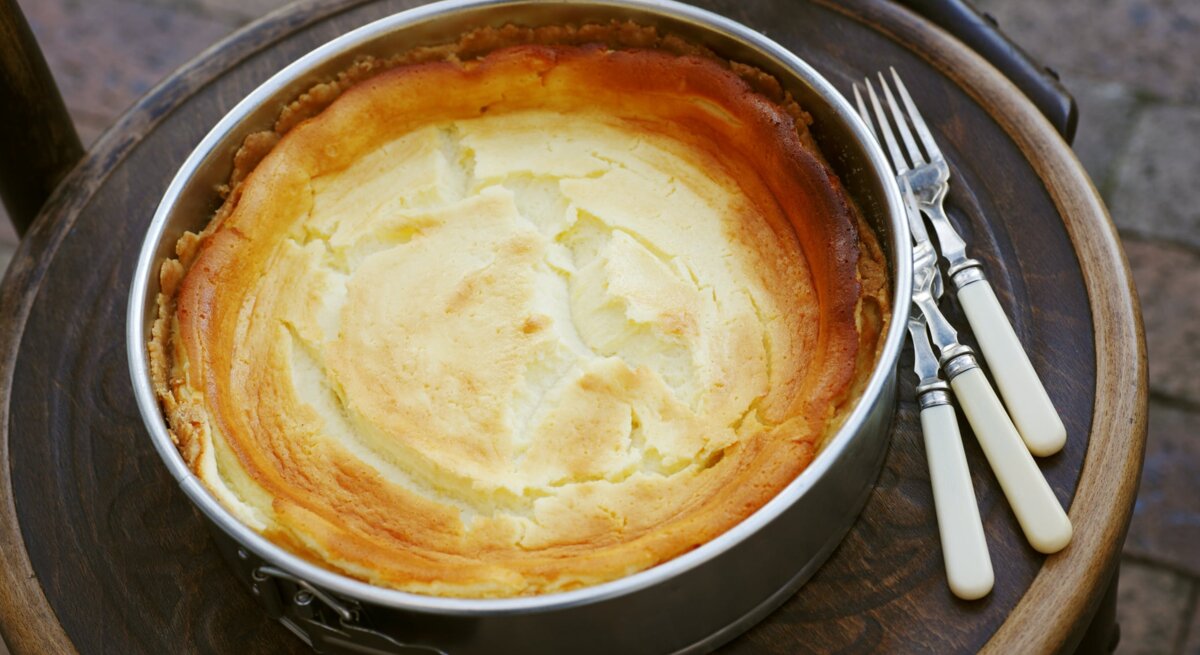 Frisch gebackener Käsekuchen mit goldener Oberfläche in einer Springform. 
