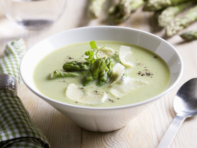 Spargelcremesuppe mit Parmesan in weißer Schale garniert mit Spargelköpfen.  | © StockFood / Oftedal, Petter
