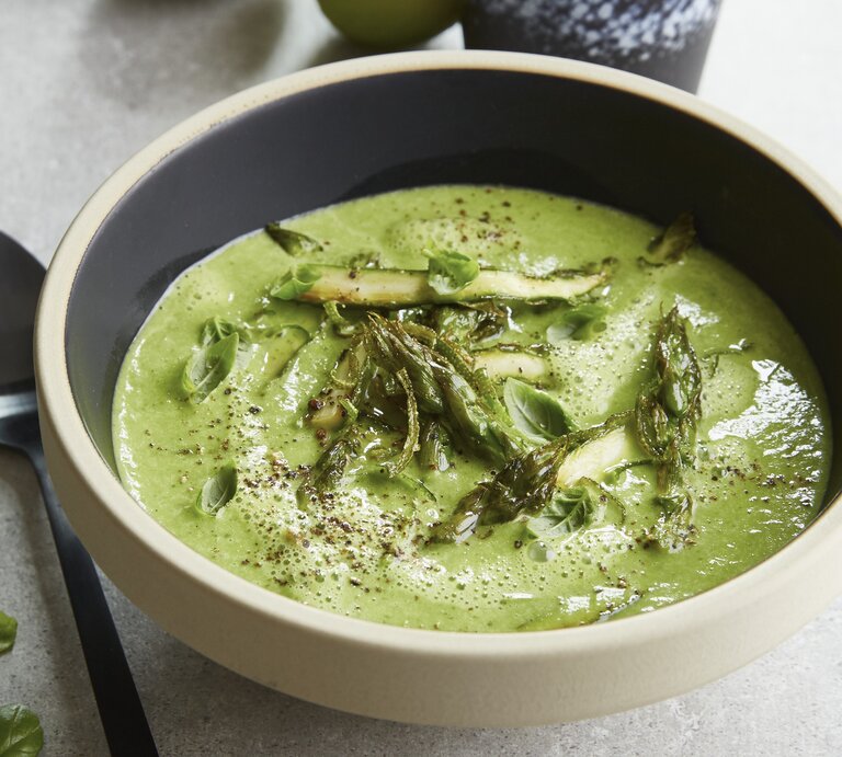 Eine graue Schale auf einem grauen Tisch mit der grünen Spargelcemesuppe. Alles von schräg oben fotografiert. | © StockFood / Gräfe & Unzer Verlag / Walsh, Nicky