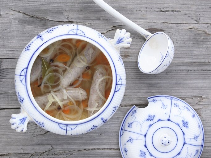 Weiß-blaues Geschirr mit dem Gericht auf einem rustikalen Holztisch direkt von oben fotografiert. | © StockFood/Raider, Peter