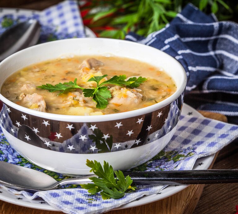 Kitschige Suppenschüssel gefüllt mit einer polnischen Graupensuppe.  | © iStock/arfo