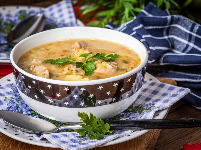 Kitschige Suppenschüssel gefüllt mit einer polnischen Graupensuppe.  | © iStock/arfo