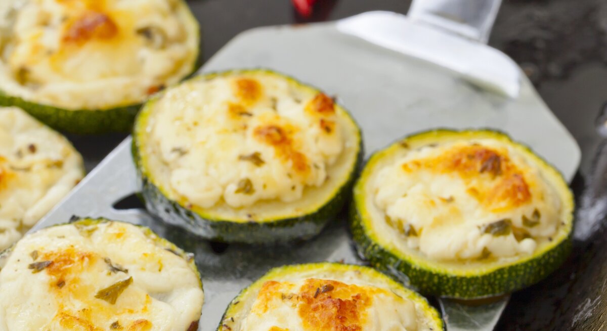 Zucchinischeiben mit Feta auf einem Blech. 
