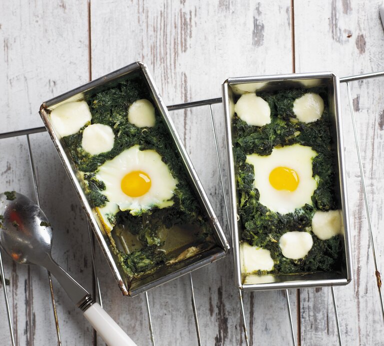 Draufsicht: Eine Form mit gegartem Spinat und gegarten Eieren. | © StockFood