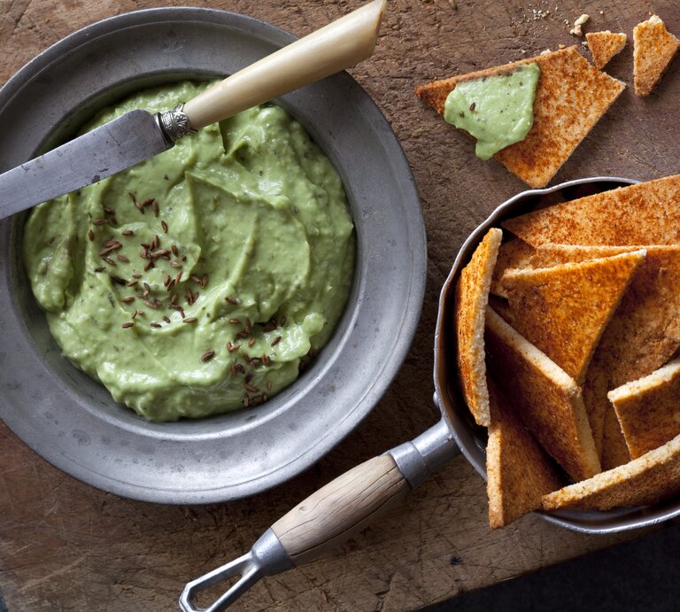 Draufsicht: Eine Schale mit einem Dip und Cräcker auf dunklem Untergrund. | © StockFood/Hammond, Louise