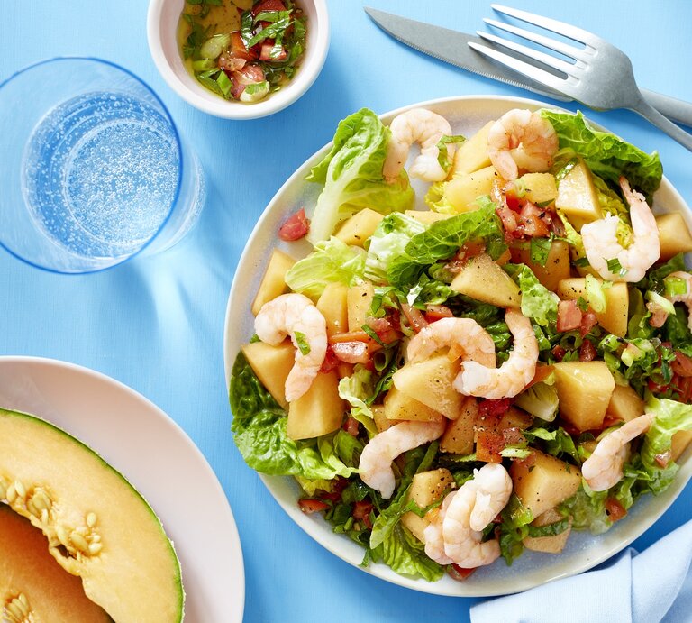 Melonensalat mit Garnelen auf weißen Tellern auf blauem Hintergrund. | © EAT CLUB/Isabell Triemer