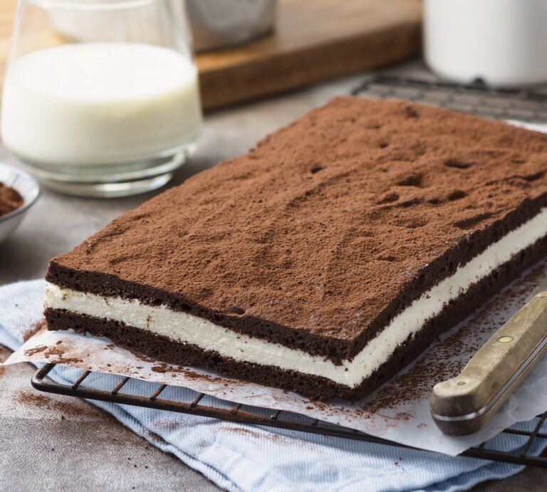 Die selbstgemachte Milchschnitte auf einem schwarzen Gitter und grauem Küchentisch. Alles von schräg oben fotografiert. | © StockFood / ZS Verlag / Speck, Sabrina